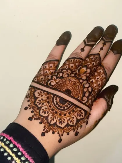A lovely half-mandala design on the back of the hand, with a clean line separating it from the detailed finger work.