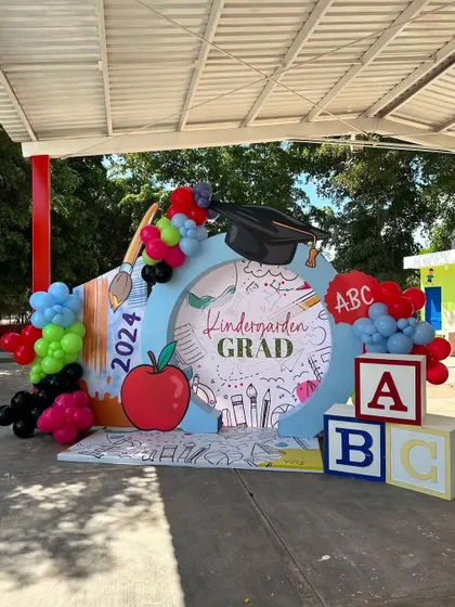 A "Kindergarden Grad" photo booth. I can create themed setups for any milestone, including school graduations, complete with fun props and backdrops.