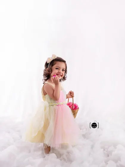 A playful, candid shot of our little flower girl, sharing a secret with her basket of flowers.