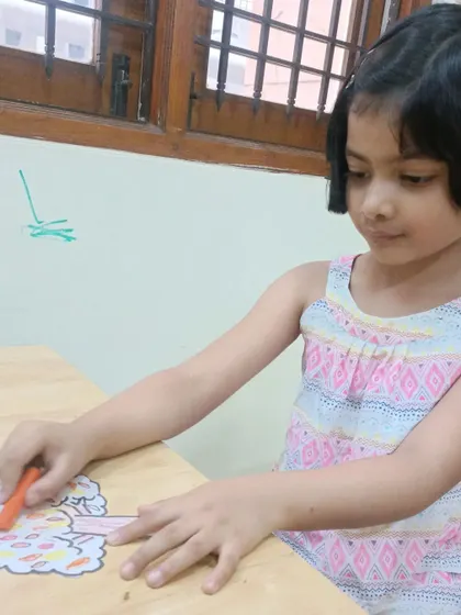 A duplicate image showing a child focused on her art project.