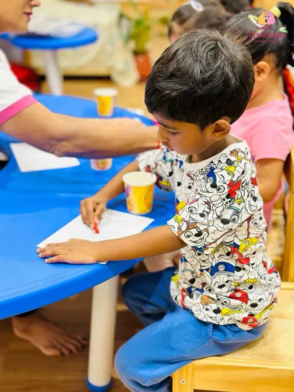 A young boy carefully works on a drawing, demonstrating the focus and fine motor skills that our program helps to develop.