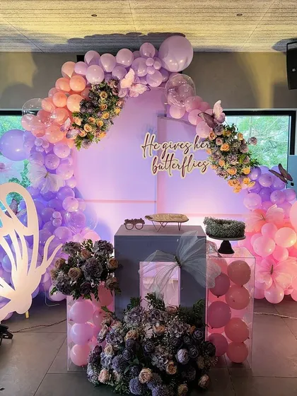 Another angle of the butterfly-themed stage, showing the full arrangement with pedestals for the cake and floral displays.