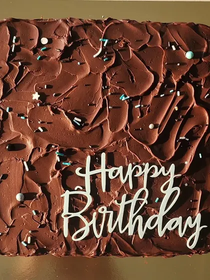A classic square chocolate birthday cake. This cake is layered with my signature dark chocolate ganache and has a rustic, textured finish on top, complete with sprinkles for a bit of fun.