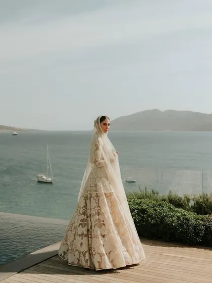 The bride stands against the backdrop of the Aegean Sea in Turkey. Our experience with destination weddings means we understand how to leverage stunning natural landscapes to create truly epic and beautiful photographic moments.