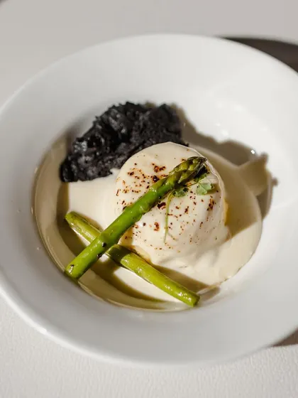Another example of a sophisticated small plate, featuring a poached egg, asparagus, and a savory crumble. This style of service allows guests to mingle while enjoying high-quality, chef-plated dishes.