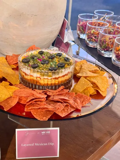 Our 7-layer Mexican dip, a crowd-pleasing centerpiece, served with colourful tortilla chips.