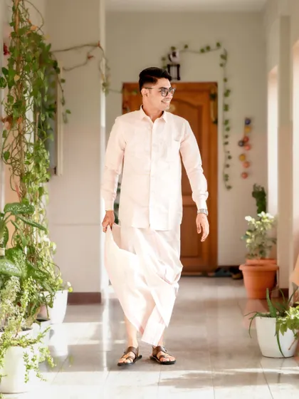 A relaxed and happy groom, captured in motion as he walks down the same beautiful corridor.