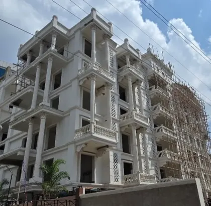 A daytime view of the Sikaria building in Guwahati under construction, with scaffolding still in place.