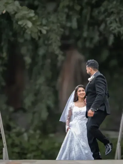 A wide shot of the couple in a park setting, creating a sense of a private, shared moment in the midst of nature.