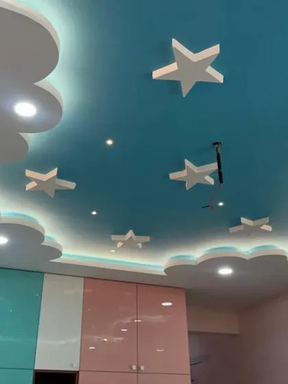 Another angle of the sky-themed false ceiling, showing how it transforms the entire room. Paired with colorful wardrobes, this design element makes the space truly special for a child.