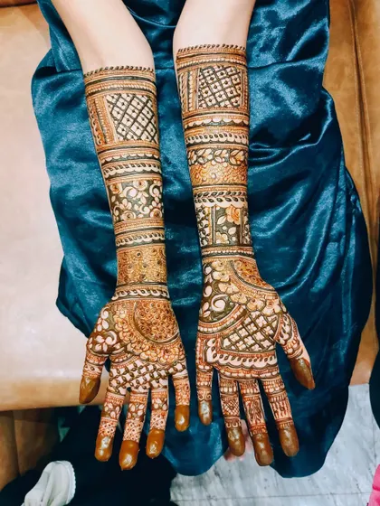 A symmetrical bridal design featuring bands of geometric patterns and floral motifs, creating a classic and elegant look.