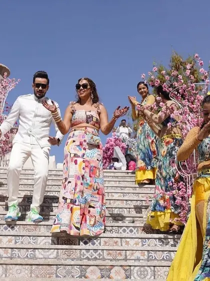The couple making their way down the stairs during their vibrant carnival event. Every part of the celebration is an opportunity for a choreographed, stylish moment.