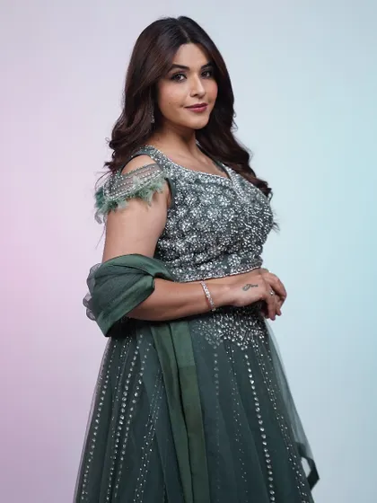 This dark green lehenga is all about quiet elegance. The tone-on-tone embroidery and feather details create a sophisticated look for any evening affair.
