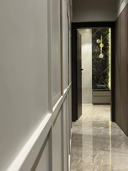A view down a corridor in the Juhu apartment, where I used reflective marble flooring and contrasting wall treatments to create a sense of length and luxury. The lighting is designed to highlight the different materials.