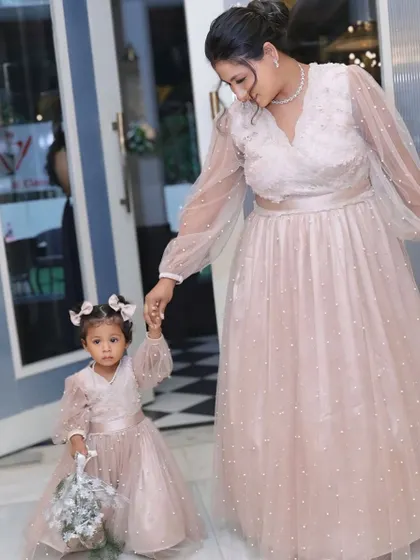 Delicate and dreamy, this matching set in soft pink features sheer, pearl-studded balloon sleeves. It's a beautiful option for a birthday party or a special event.