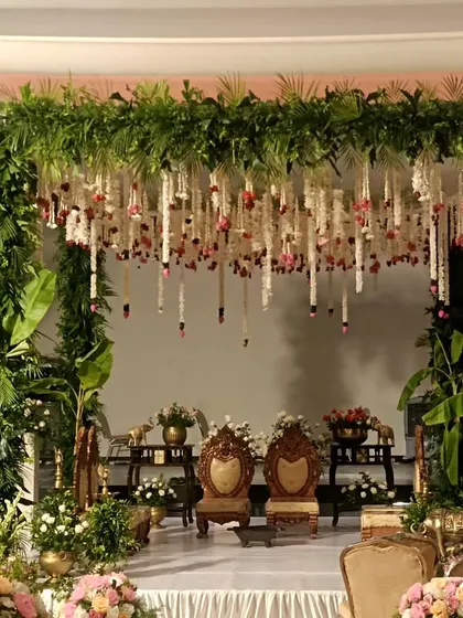 A classic South Indian mandap with lush green pillars and hanging tuberose garlands.