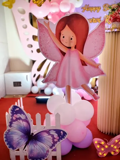 A cute fairy character cutout on a balloon pillar, part of the whimsical party decor.