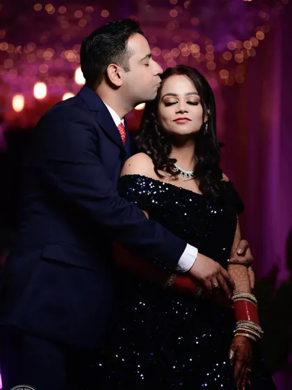 A tender kiss on the forehead during the reception. This intimate gesture, set against a soft, glowing background, creates a romantic and heartfelt portrait of the newlyweds.