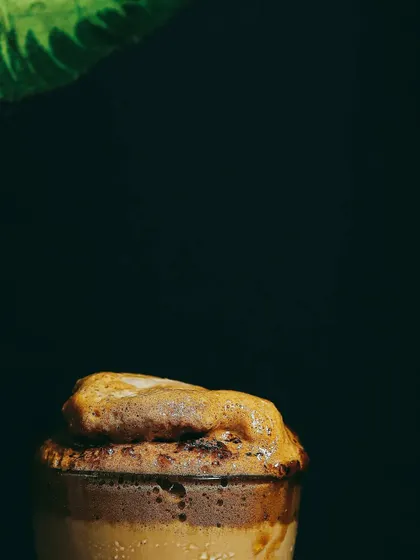 Another minimalist take on Dalgona coffee, focusing on the fluffy, cloud-like foam. The dark setting and simple composition create a powerful and artistic image.