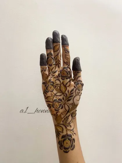 A full-hand floral design with filled fingertips, a traditional touch.