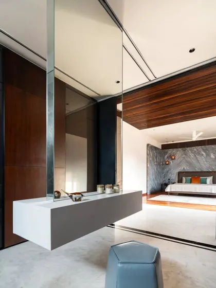 A suspended vanity with a wrap-around mirror creates an ethereal dressing area in the Timber Edge project. This floating element blurs boundaries and enhances the sense of space.