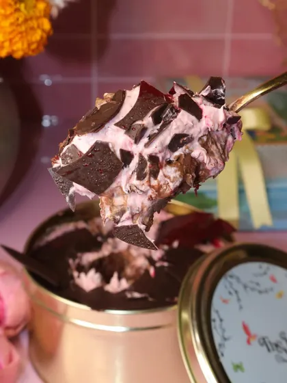 Another tempting spoonful of our Raspberry Chocolate Dream Cake. You can see the rich layers and chocolate shards mixed into the light, fruity cream, all ready to be enjoyed.
