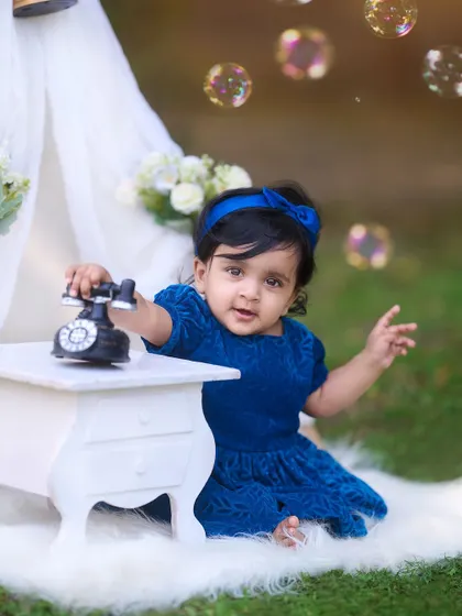 A classic and cozy setup for a pre-birthday shoot. This portrait features a simple teepee tent, a vintage telephone prop, and bubbles to create a sweet and timeless look.