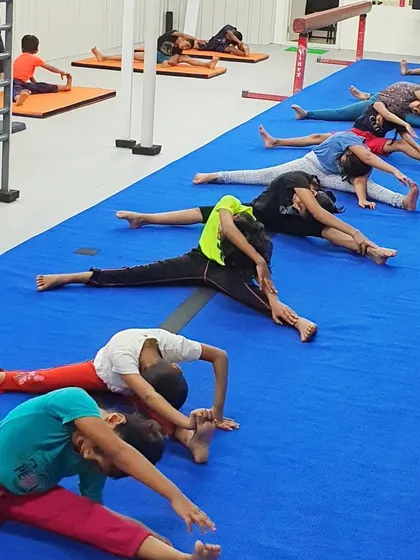 A group of students works on their straddle stretches, a key component of our flexibility training to help them achieve splits.
