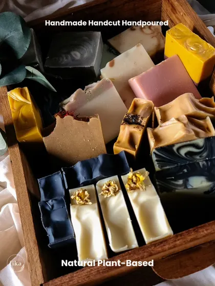 This wooden crate is filled with an assortment of my handmade, hand-cut, and hand-poured soaps. It showcases the variety of natural, plant-based bars I create, from deep indigo swirls to creamy white bars topped with botanicals.