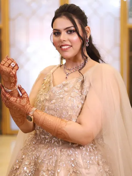 A happy bride showing off her ring, her smile and glowing makeup lighting up the photo.