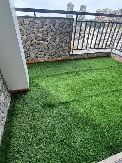 A high-angle view of the completed balcony, showing how the green turf contrasts beautifully with the stone-look walls.