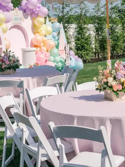 A closer view of the adult tables, with beautiful floral centerpieces and a view of the main party setup in the background.