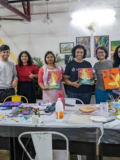 A group of proud artists with their finished texture and pour paintings.