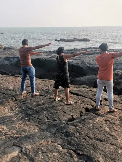 Team members striking a pose on the rocky shores of St. Mary's Island, a unique geological formation we visit during our Malpe tour.