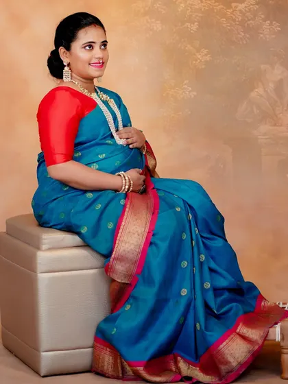 A classic seated portrait for a traditional maternity shoot. I used a bright red lip to add a pop of color against the blue saree, creating a joyful and festive look.