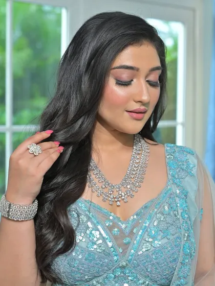 A close-up of a stunning layered zircon necklace, paired with a matching bracelet and ring. This complete set offers a glamorous and cohesive look, perfect for a bride's reception.