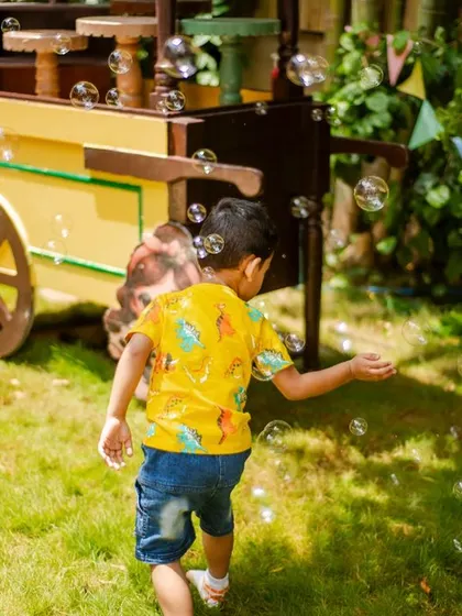 Pure, simple fun. A little guest enjoys chasing bubbles in the garden at the farm-themed party. I always ensure there are activities to keep the children entertained.