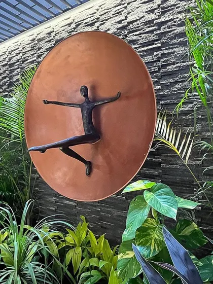 I designed this serene sunken basement court as a hidden green oasis. A rustic chiseled stone backdrop is enveloped in lush leafage, creating a perfect frame for a joyful piece of art where nature and creativity can dance.