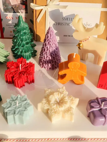 A close-up of my small, colorful Christmas candles. The detail on each one, from the gingerbread man's buttons to the reindeer's bell, is done by hand.