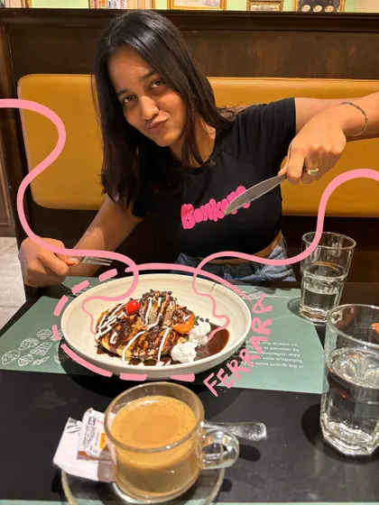 Tackling a plate of delicious Ferrero Rocher pancakes. The pink doodle adds a playful touch to this dessert moment.