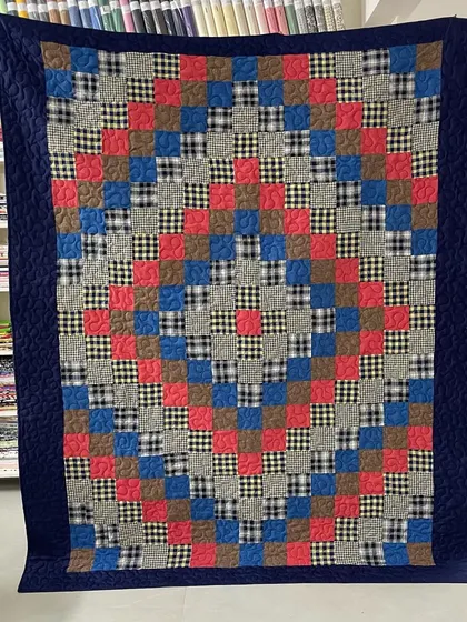 A full view of a memory quilt made from checked shirts, arranged in a classic Irish Chain pattern.