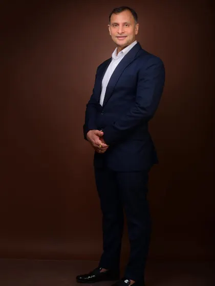 A full-length formal portrait against a studio backdrop. This provides a clean, polished image that can be easily used across various media formats.