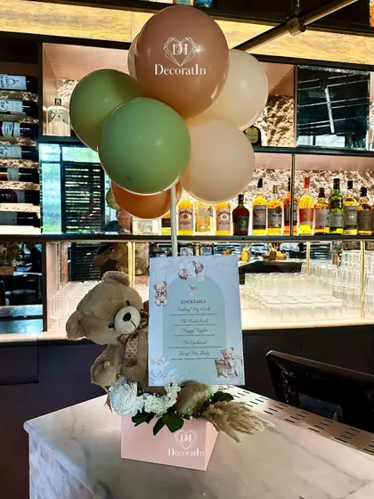 The custom bar menu displayed with a cute teddy bear and balloon arrangement.