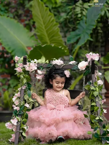 A beautiful, happy smile from a little princess on our floral swing. The lush green background makes the pink dress pop.