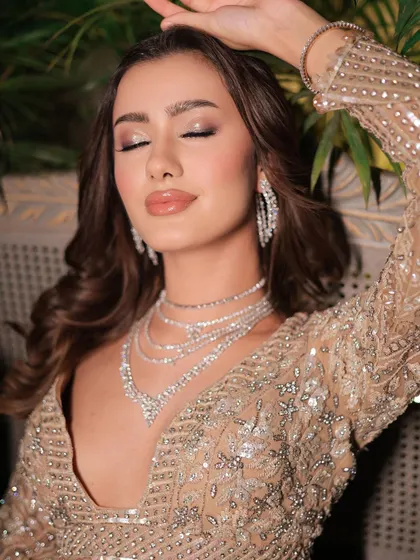An expressive, eyes-closed shot that highlights the glossy, wet-look eyeshadow. This is a very modern and high-fashion party look.