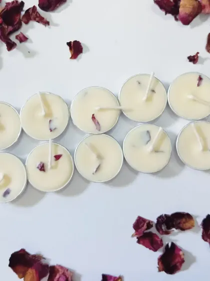 A wider view of a set of ten rose petal tealights, surrounded by loose, dried rose petals to show the natural ingredients I use.