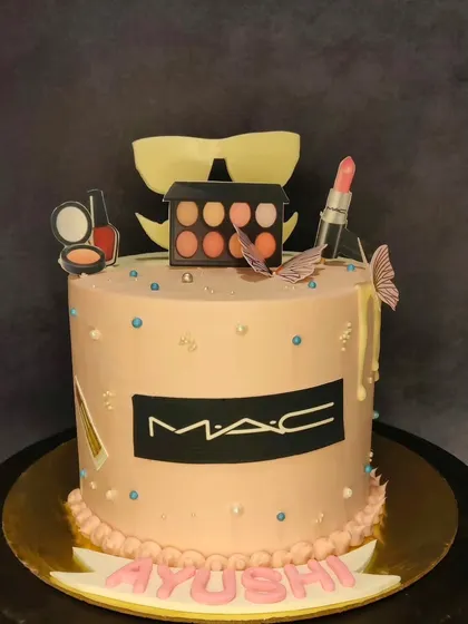 A cake for the makeup lover, themed around MAC Cosmetics. This cake is topped with edible replicas of lipstick, eyeshadow palettes, and nail polish, all crafted with precision.