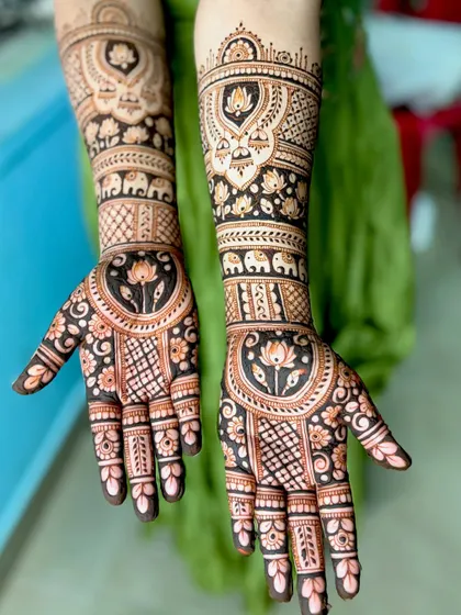 An elegant bridal design featuring lotus mandalas on the palms and elephant motifs on the arms. The use of negative space makes the lotuses stand out.