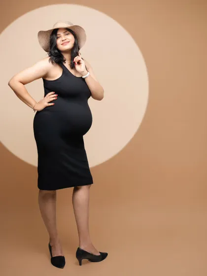 Glow, grace, and a growing bump. This mama-to-be is embracing her journey with confidence and style in a chic black dress and hat.
