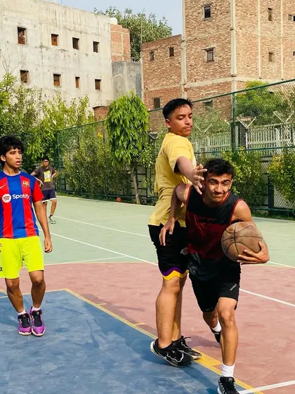 A player dribbles past a defender, demonstrating the ball-handling skills we develop in our drills.